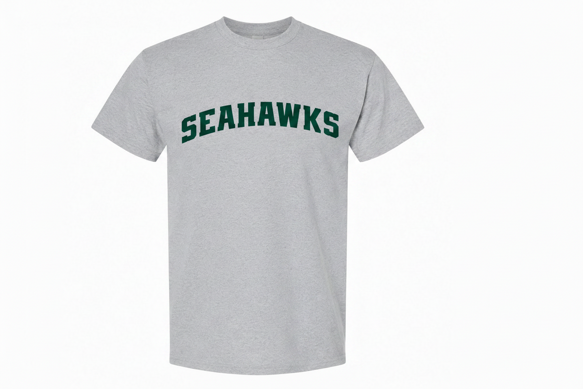 A heather gray short-sleeve crewneck t-shirt featuring the word 'SEAHAWKS' printed in dark green arched letters across the chest, with a small football graphic underneath.